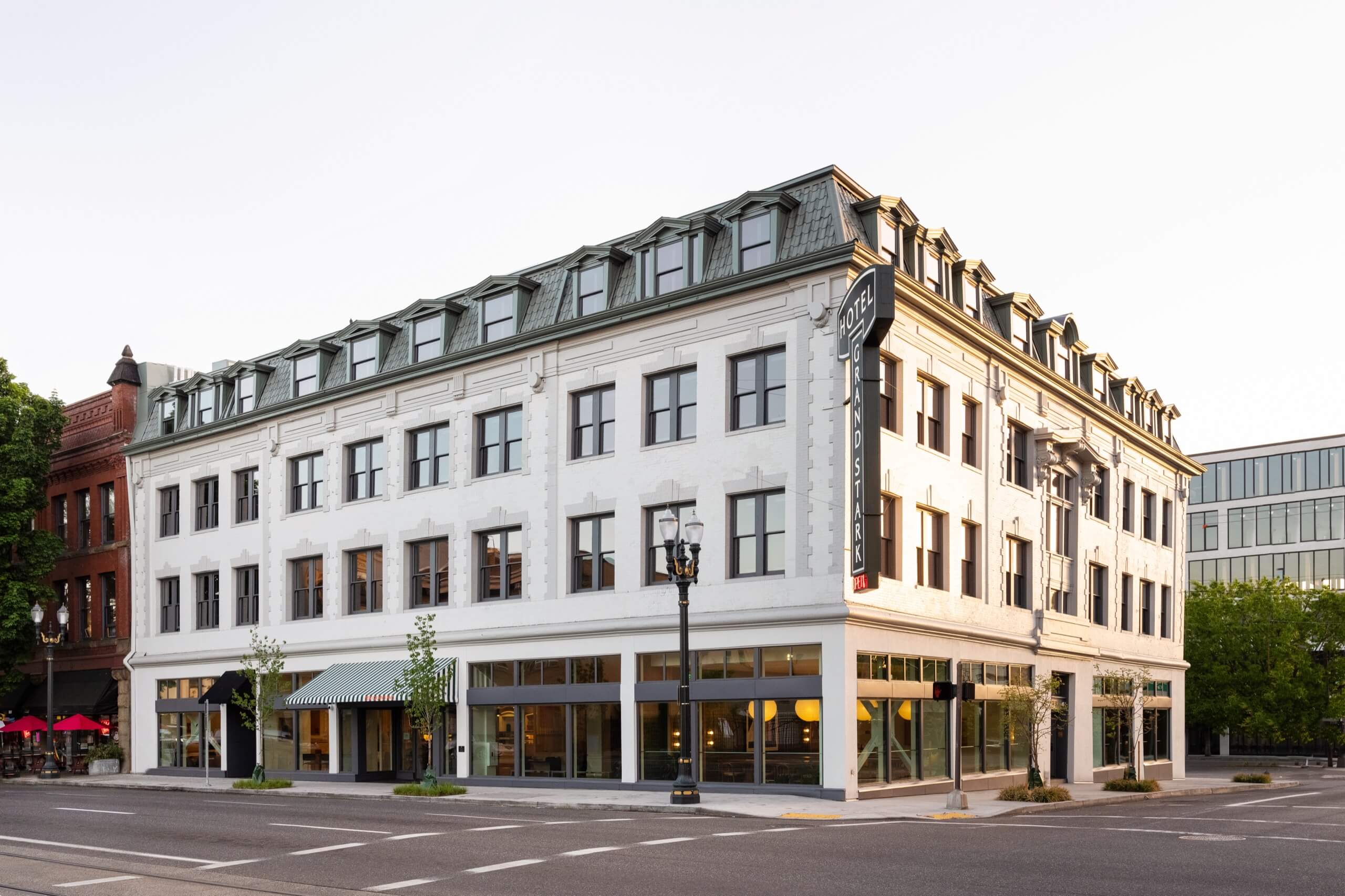 A white, multi-story building with a sign reading 'Hotel Grand Stark'
