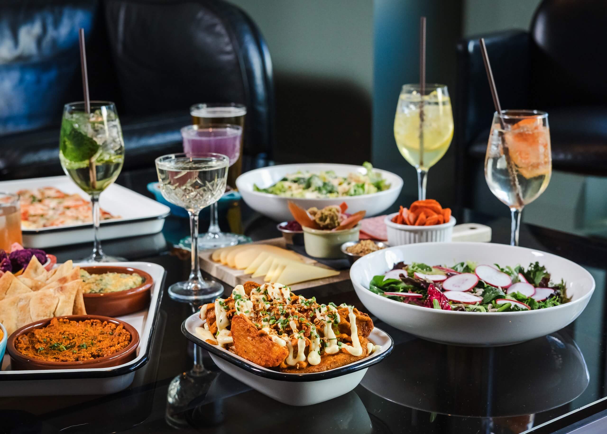 A table set with various dishes and glasses of drinks
